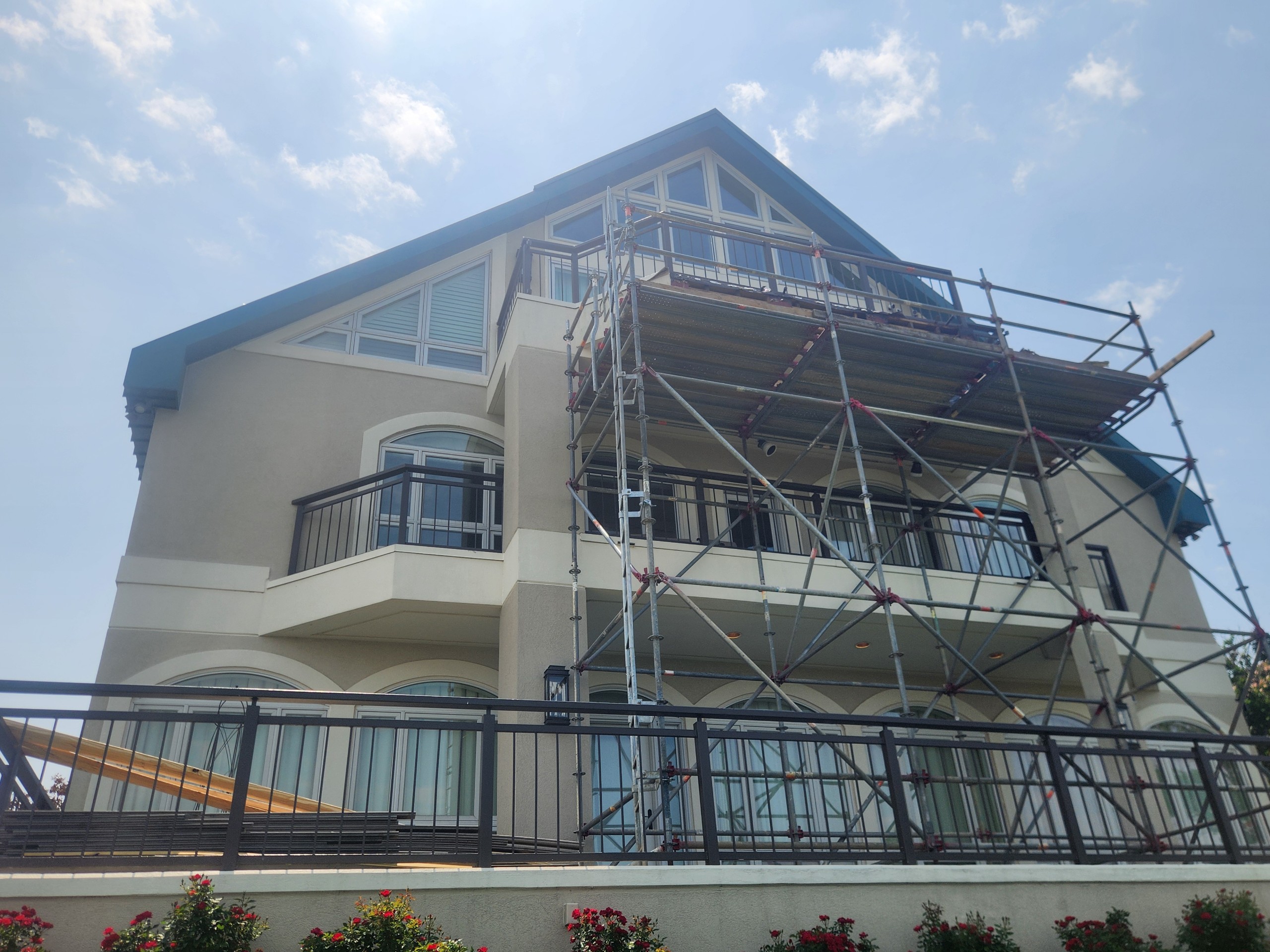 Large residential exterior painting project with scaffolding